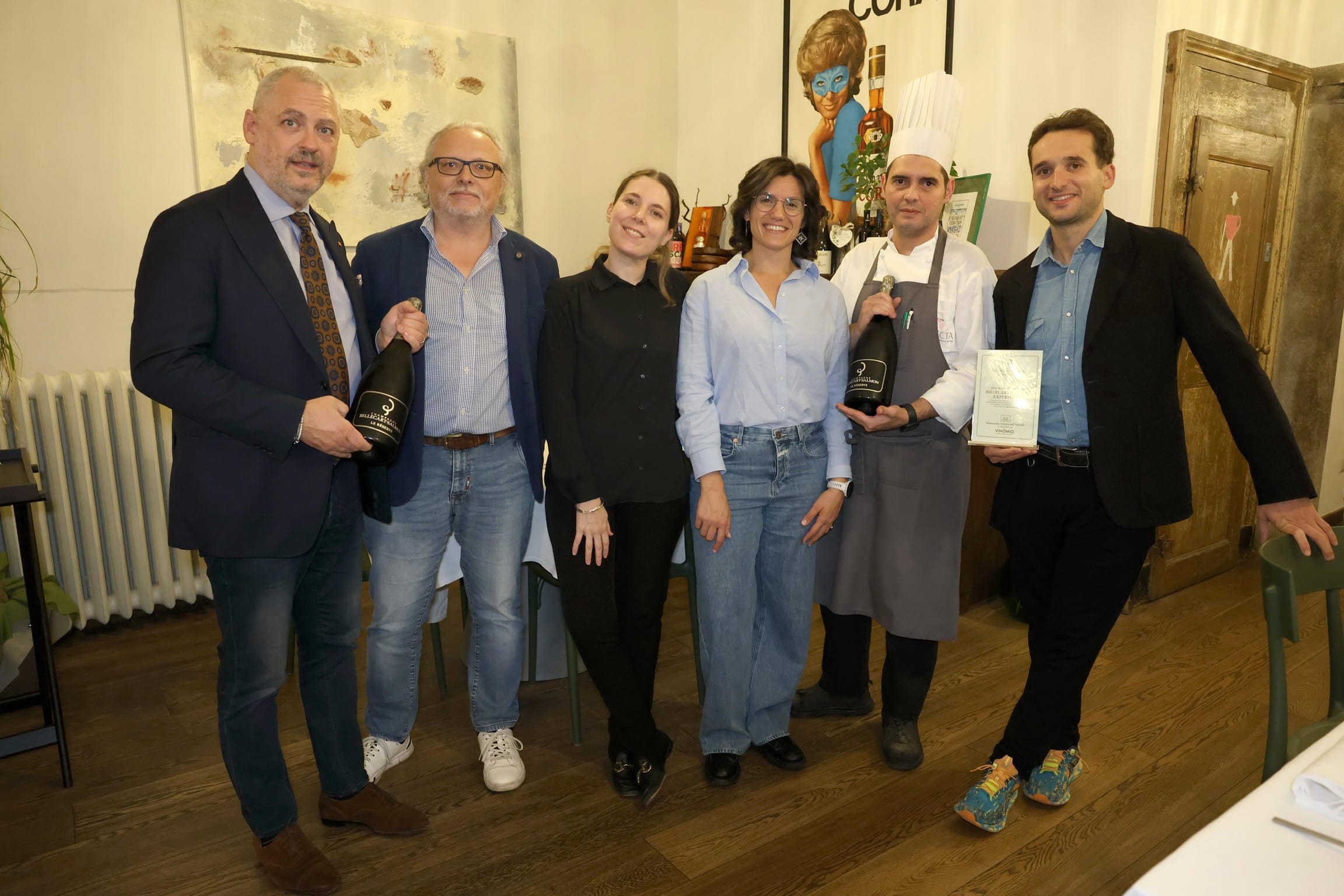 Gruppo di sei persone con bottiglie di Champagne Billecart-Salmon e il menù